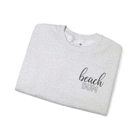 Beach Bum Ash Grey Crewneck Sweatshirt folded, featuring stylish text design on soft medium-heavy fabric. Perfect for beach lovers.